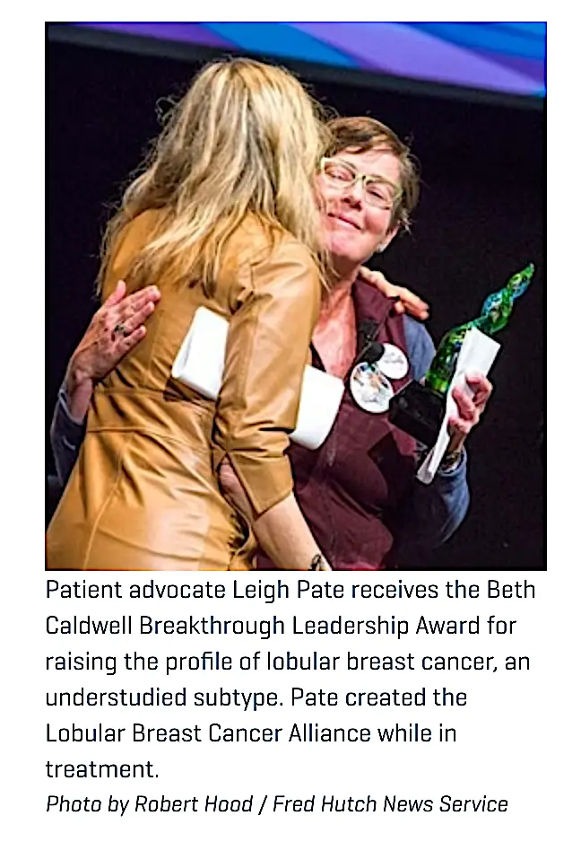 Fred Hutch News Service Photo of LBCA leader Leigh Pate holding a trophy hugging NWMBCC co-chair Lynda Weatherby
