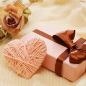 Gift box with yarn rose next to it