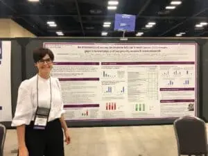 Dr. Christine Desmedt in front of ILC research poster.